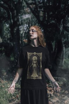 The Witch T-shirt: be transported to a world where the mystical and the tangible meet. 👕 FEATURES * Made with 100% Airlume combed and ring-spun cotton * lightweight fabric (4.2 oz/yd² (142 g/m that is easy to layer, breathable. * Perfect for active and leisure wear.  * The retail fit that is perfect for casual and semi-formal settings. * Manufactured in the US and internationally in humane, no-sweat-shop, sustainable way and is part of the Fair Labor Association as well as Platinum WRAP certified. * The tear-away label minimizes skin irritations. * Fabric blends: Ash and Heather Prism colors - 99% Airlume combed and ring-spun cotton, 1% polyester; Heather and Solid Blend colors - 52% cotton, 48% polyester; Athletic Heather and Black Heather - 90% cotton, 10% polyester. 📏 SIZING See size Mystical Cotton Crew Neck T-shirt, Mystical Crew Neck Cotton T-shirt, Mystical Style Cotton Crew Neck T-shirt, Mystical Graphic Print Crew Neck Top, Mystical Style Cotton T-shirt With Crew Neck, Gothic T Shirt, Witch Tshirt, Graphic Apparel, The Witch