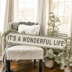 a sign that says it's a wonderful life sitting on a bench in front of a window