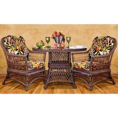 two wicker chairs and a table with fruit on it