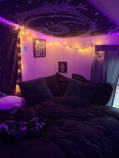 a bedroom with purple lights and black comforter