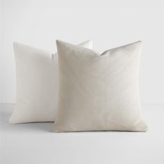 two white pillows sitting next to each other