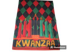 an image of kwanzaa with candles in the center on a tablecloth that says kwanzaa