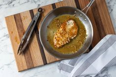 a skillet with some food in it on a cutting board next to a pair of scissors