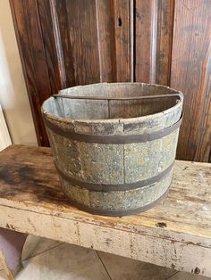 an old wooden bucket sitting on top of a bench