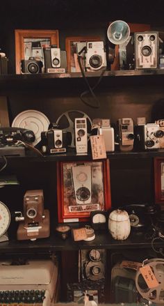 many old cameras are on display in a room