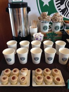 starbucks coffee cups and pastries are arranged on a table in front of an assortment of desserts