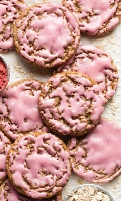 some cookies with pink icing and sprinkles next to a bowl of oatmeal