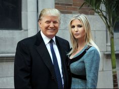 a man and woman standing next to each other in front of a building with a palm tree