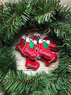 two red christmas stockings hanging from a wreath