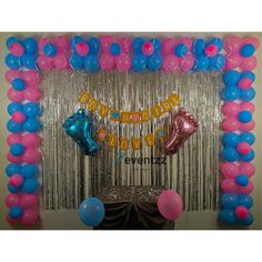 balloons and streamers decorate the entrance to a party with blue, pink, and silver decorations