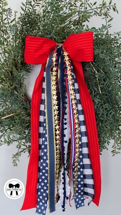 a christmas wreath with red, white and blue ribbons