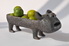 a hippo planter with lemons and limes in it's mouth