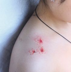 a woman's breast with red ink on it and flowers in the middle of her chest