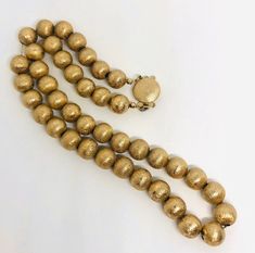 Beautiful vintage textured gold tone/plated beaded ball necklace. Lovely detailed texture to gold tone/plated metal beads strung on chain. Has large secure push in clasp. Not lightweight but comfortable to wear. Beads measure 3/8 inch across and total length is 17 inches. Excellent vintage condition with minimal age appropriate wear. Could use a polish but as always leave that up to buyer. Beautiful beaded necklace!! Vintage Gold Polished Beads, Vintage Polished Gold Beads, Gold Metal Beads With Beaded Chain, Antique Gold Polished Beads, Antique Polished Gold Beads, Vintage Large Gold Beads, Antique Large Gold Beads, Vintage Yellow Gold Beaded Necklaces With Round Beads, Gold Polished Beads For Costume Jewelry