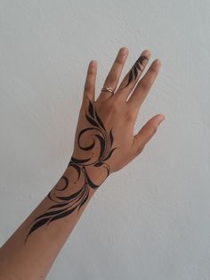 a woman's hand with black ink on it and an intricate design in the middle