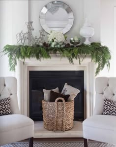 a fireplace decorated for christmas with white furniture