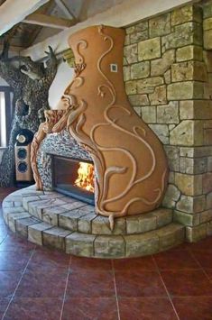 a large fireplace in the middle of a living room with stone walls and flooring