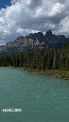 the water is very blue and green with mountains in the backgrouds on either side