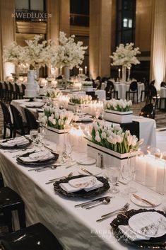 a table set up with white flowers and candles for a wedding reception at the westin