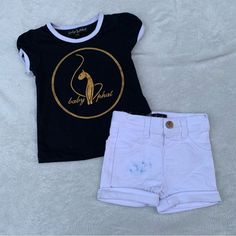 Baby Phat Black T-Shirt With White Trim This Black T-Shirt From Baby Phat Is A Versatile Addition To Your Wardrobe. Crafted From A Soft, Breathable Fabric, It Features Short Sleeves And A Contrasting White Trim On The Collar And Sleeves. The Gold Circular Logo At The Center Showcases The Iconic “Baby Phat” Text, Surrounded By A Stylized Cat Emblem. Whether You’re Running Errands Or Meeting Friends, This T-Shirt Effortlessly Combines Comfort And Style. White Button-Closure Shorts Complete Your Lo Fall Long Sleeve Shirts, Girls Loungewear, Girl Sweat, Circular Logo, Baby Phat, Sweat Set, Carters Girl, Heart Sweater, Bras And Panties