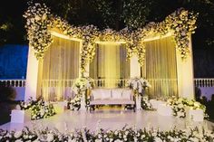 a decorated stage with white flowers and greenery