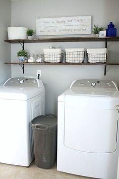 a washer and dryer sitting next to each other in a room with shelves on the wall