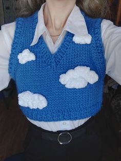 a doll wearing a blue sweater with clouds on it