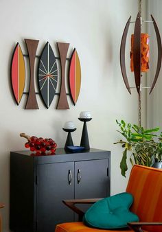 a living room filled with furniture next to a wall mounted art piece on the wall