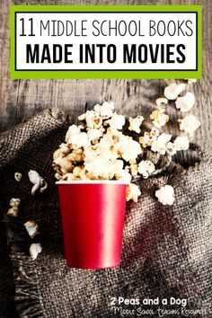 a red cup filled with popcorn sitting on top of a table next to a pile of popcorn