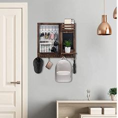 a wall mounted coat rack with shoes and purses on it, next to a door