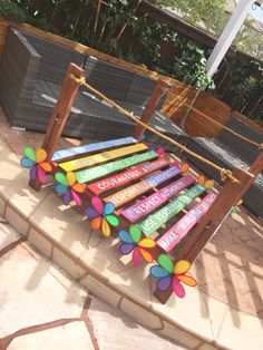 a rainbow colored wooden bench sitting on top of a patio