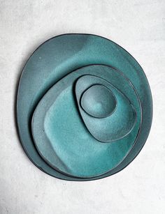 three green plates stacked on top of each other in the shape of two spirals