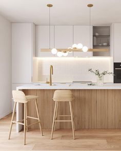 a kitchen with two stools next to an island