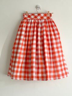 "Orange check high waist full gathered skirt. Perfect for casual outfits and special ocasions with pair of trainters or high heels. 100% cotton.  Elastic at the back of waist.  Two side pockets. Midi lenght about 70cm + 5 cm waistband. Handmade in UK.  Model wears size S.  HOW TO CHOOSE A SIZE ?   Using a measuring tape, measure the smallest part of your waist.  SIZE CHART: (CM) XS - W: 66 CM S - W: 70 CM M - W: 74 CM  L - W: 78 CM  XL - W: 82 CM  CARE INSTRUCTIONS: Hand wash only, do not bleach, hang dry, do not tumble dry, press with a cool iron on the reverse side.  Please message me before purchasing so I can check availability. If you wish this skirt in any other fabric, shorter or longer \"send message to seller\" and we can try to make something especially for you. *Depends on compu Gingham Skirt For Summer Picnic, Summer Gingham Skirt For Picnic, Summer Plaid Pleated Skirt, Plaid Long Skirt For Spring, Fitted Cotton Skirt For Picnic, Plaid Cotton Lined Skirt Bottoms, Plaid Cotton Relaxed Skirt, White Skirt For Spring Picnic, Casual Gingham Cotton Skirt