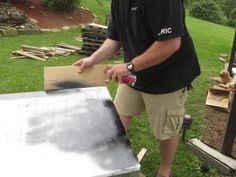 a man standing next to a grill in the grass