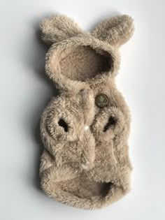 a close up of a stuffed animal's head on a white surface with one eye open