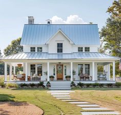 a white house with a blue roof and steps leading up to the front door,