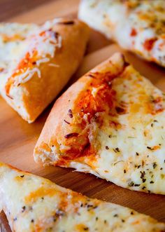 several slices of pizza sitting on top of a wooden cutting board