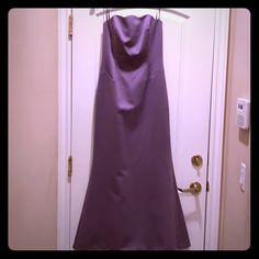 a purple dress hanging on a door with a hanger in front of the door