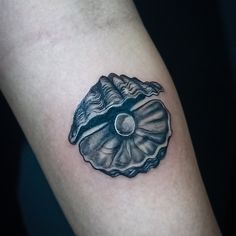 a black and white photo of a seashell tattoo on the right arm, with an ocean wave coming out of it's shell