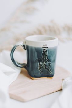 a coffee cup with a drawing of a horse on it sitting on a wooden tray