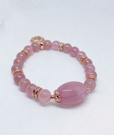 A lovely Rose Quartz barrel and beads are handpicked for this beautifully designed piece of bracelet with high quality rose gold plated spacers with cubic zirconia inserts and a rose charm at the other end of the wrist. This rose quartz is obtained from Madagascar and the energy is of positive vibration for healing and attraction of love. Rose quartz is a stone of universal love. It restores trust and harmony in relationships, encouraging unconditional love. Rose Quartz purifies and opens the he Rose Gold Rose Quartz Crystal Bracelet With Round Beads, Rose Gold Rose Quartz Jewelry With 8mm Beads, Rose Gold Crystal Bracelet With Round Rose Quartz Beads, Rose Gold Beaded Bracelets With Gemstone Beads, Elegant Pink Charm Bracelet With Round Beads, Rose Gold Beaded Bracelets With 8mm Beads, Rose Gold Bracelets With Gemstone Round Beads, Rose Gold Bracelet With Round Gemstone Beads, Elegant Rose Gold Bracelets With Faceted Beads