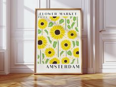 a yellow flower market poster hanging on the wall in an empty room with white walls