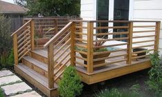 a wooden deck with planters on it and steps leading to the back yard area