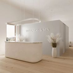 a white reception counter in front of a wall with the words whineness & spa on it