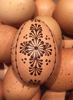 an egg is sitting on top of eggs with designs painted on it's side