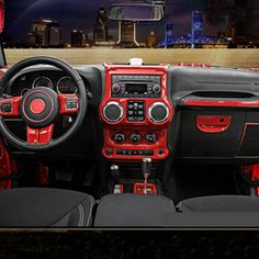 the interior of a car with red trims and black leather seats in front of a cityscape