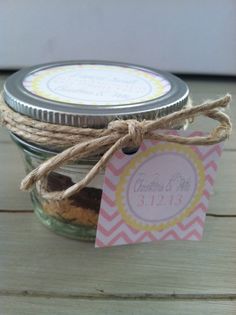 a jar filled with cookies sitting on top of a wooden table next to a tag