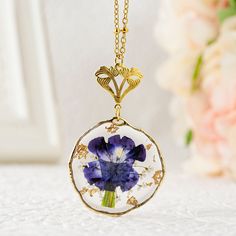 "Handmade real birth flower necklace featuring a dried pressed Morning Glory flower pendant. The birth flower is adorned with Queen Anne's lace and gold flakes. The beautiful dried flower pendant is embedded in a UV resin 32mm (1.26 inch) round irregular setting and is available in a gold or silver finish. The high quality stainless steel beaded chain is enhanced by a Victorian style floral bail. You can choose your chain length between 18\", 20\", 24\", 30\" inches. Your jewelry will arrive in Bohemian Gold Flower Necklace, Gold Bohemian Flower Pendant Necklace, Bohemian Gold Flower Pendant Necklace, Bohemian Gold Jewelry With Flower Decoration, Gold Bohemian Flower Necklace For Gift, Bohemian Gold Flower Necklace Gift, Flower Pendant Necklace With Pressed Flowers, Gold Flower Pendant With Pressed Flowers, Gold Flower Jewelry With Pressed Flowers