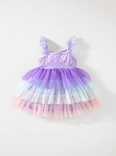 Dive into enchanting style with our Baby Girl's Mermaid Tail Pattern Color Block Mesh Layered Frilled Hem Spaghetti Strap Dress! This mesmerizing ensemble features a whimsical mermaid tail pattern combined with a delightful color block design, creating a look that's as magical as it is adorable. The mesh layered frilled hem adds an extra touch of charm, perfect for your little one's twirl-worthy moments. With adjustable spaghetti straps for a comfortable fit, this dress is ideal for any special Pink Mermaid Dress For Summer, Playful Multicolor Sleeveless Princess Dress, Purple Mermaid Dress For Summer, Summer Mermaid Dress With Ruffles, Ruffled Mermaid Summer Dress, Purple Ruffled Mermaid Dress, Summer Purple Mermaid Dress With Mermaid Hem, Purple Summer Mermaid Dress, Summer Purple Mermaid Dress